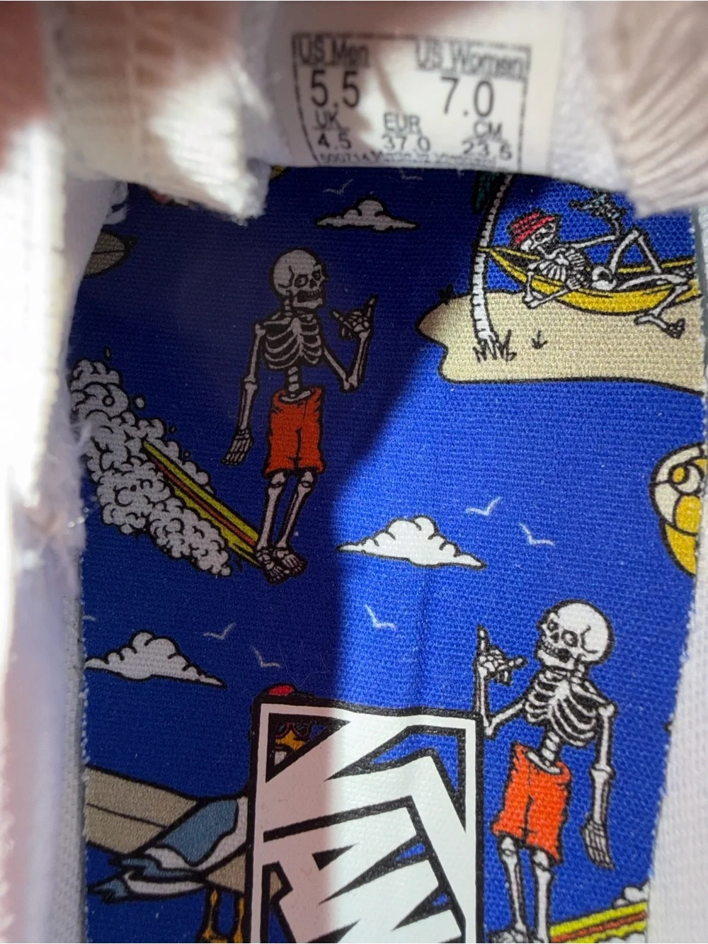Vans White Slip-On Sneakers with Black skeleton doodles